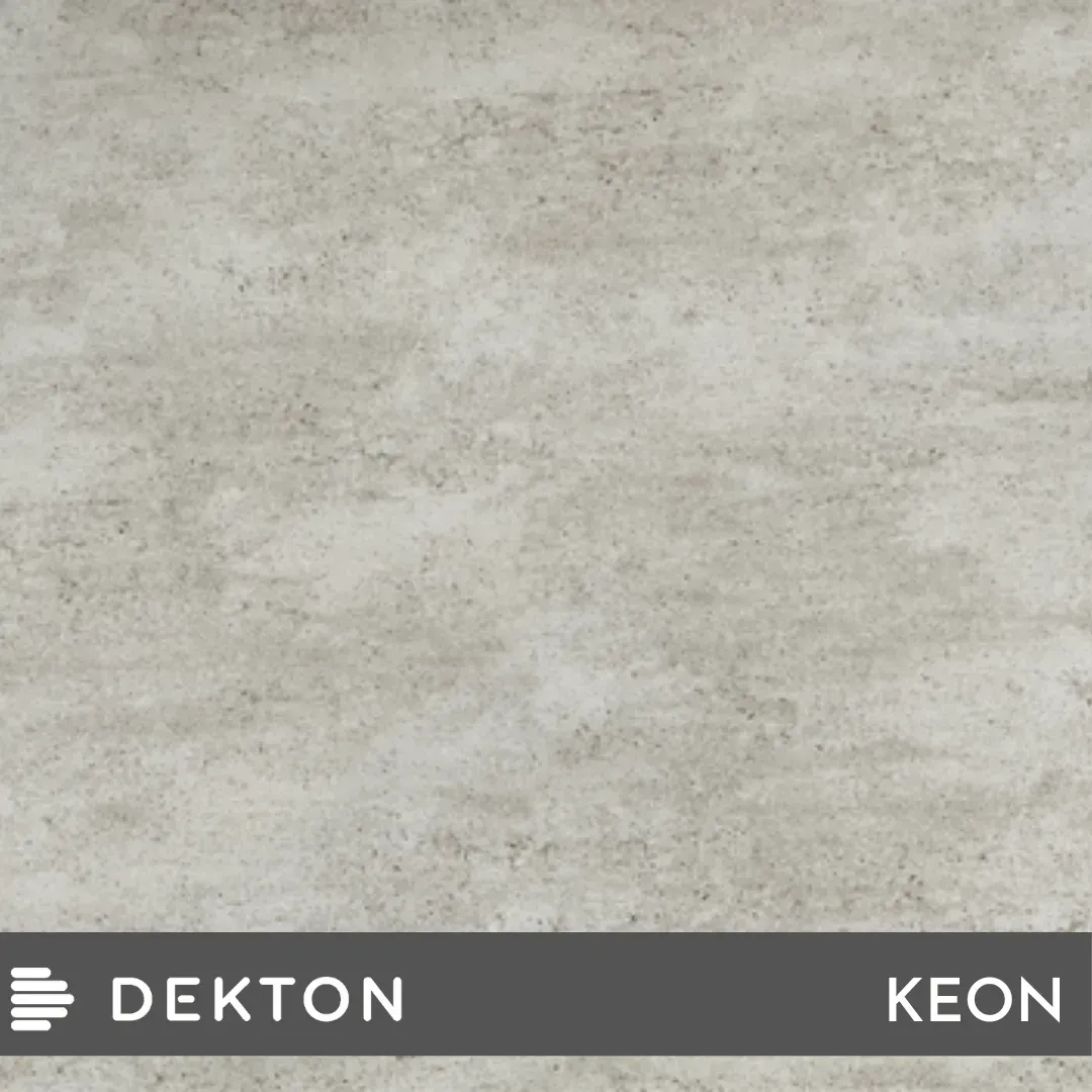 Textura de hormigón gris claro con una banda inferior oscura etiquetada como “DEKTON” y “KEON”.