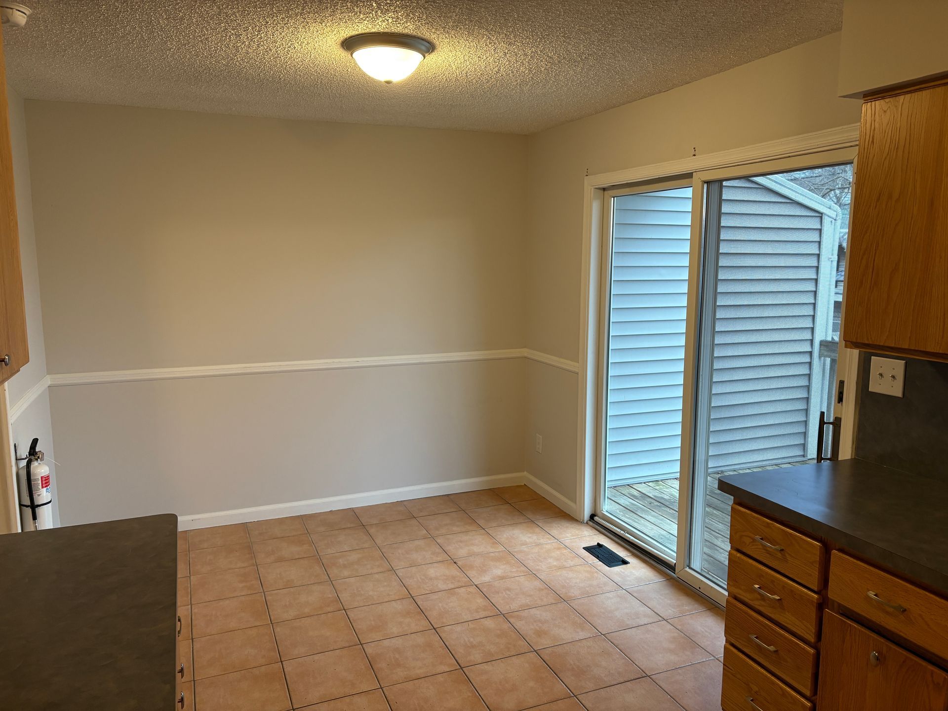 bedroom interior with beige walls, tile floor, sliding glass door, and balcony