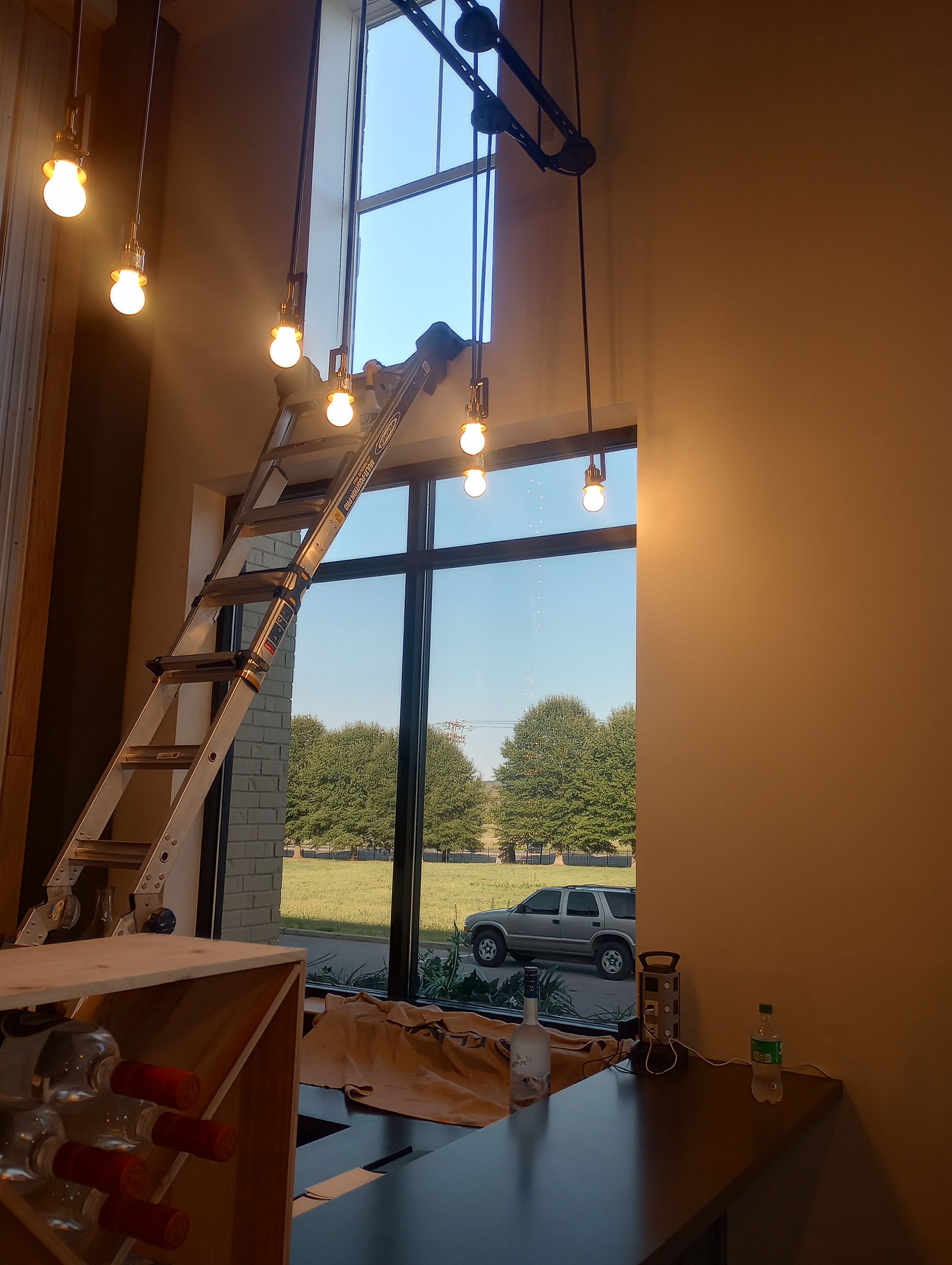 A ladder is hanging from the ceiling in a room with a large window.