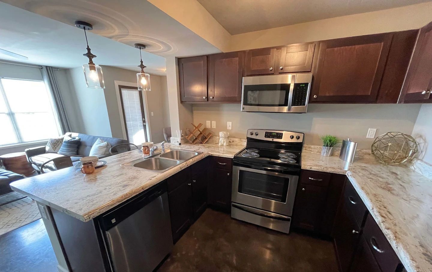 Kitchen with dark wood cabinets, stainless steel appliances, and granite countertops.