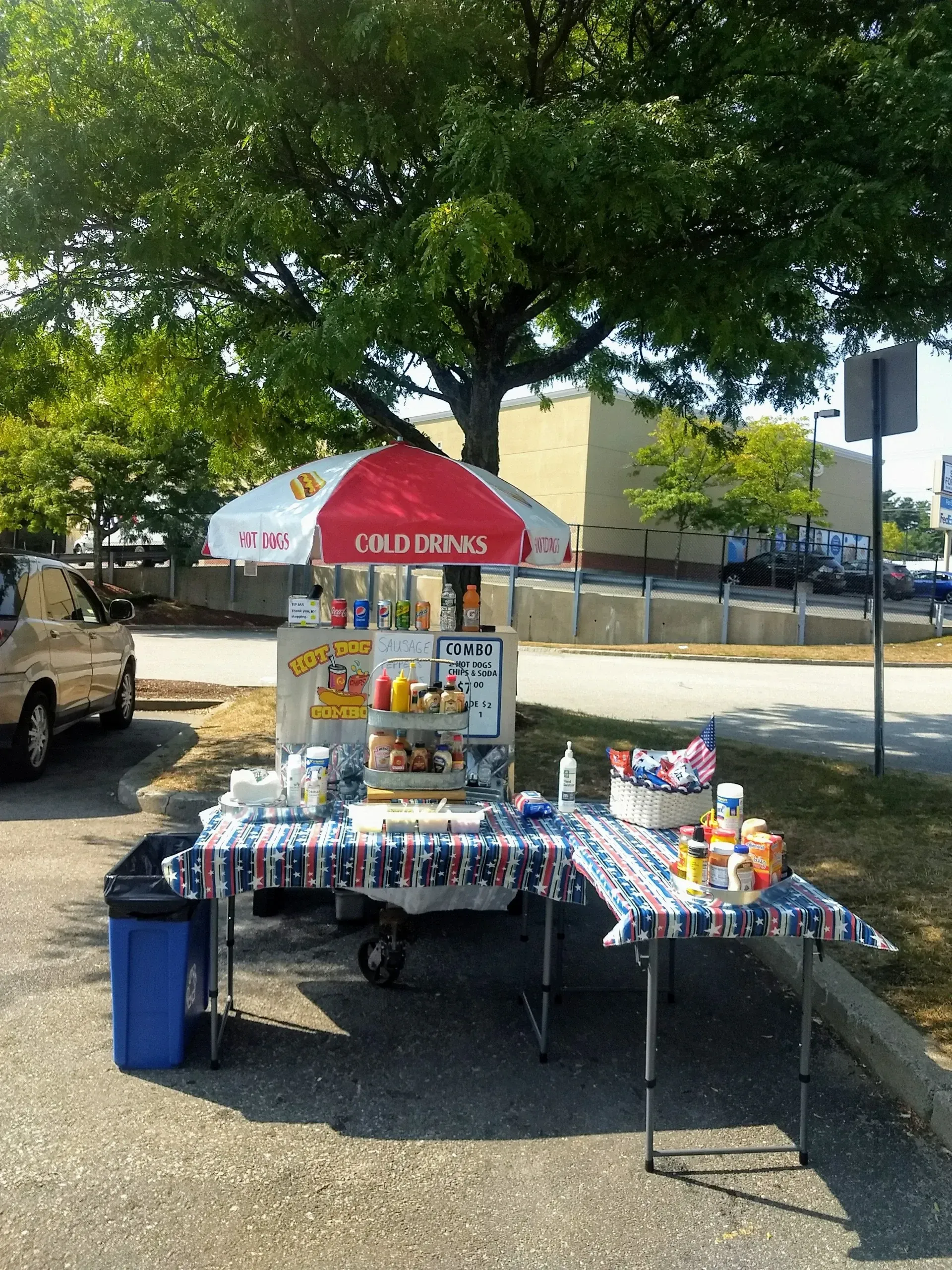 An ice cream cart with an umbrella that says ice cream on it