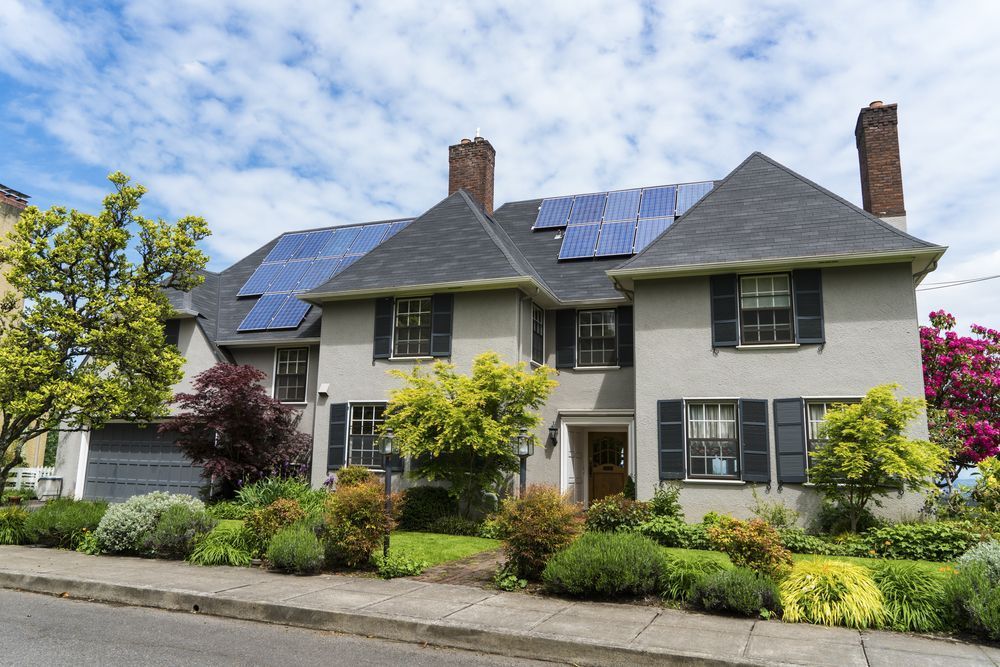 A Large House With Solar Panels on the Roof — Green Thumb Landscapes In Coffs Harbour, NSW