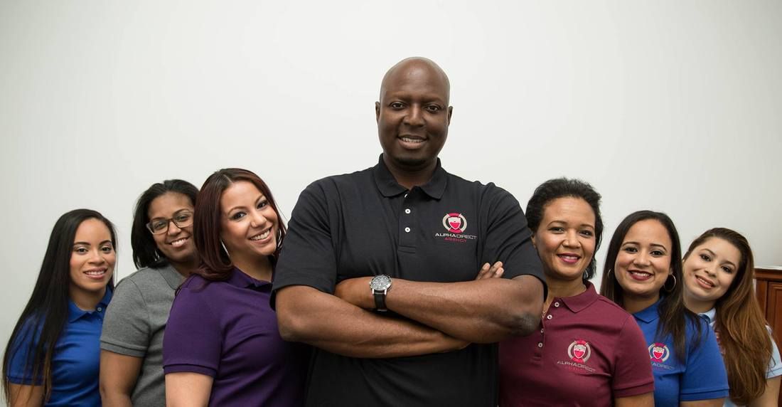 A man is standing in front of a group of women with their arms crossed.