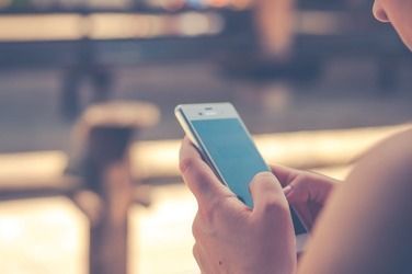 A person is holding a cell phone in their hands.