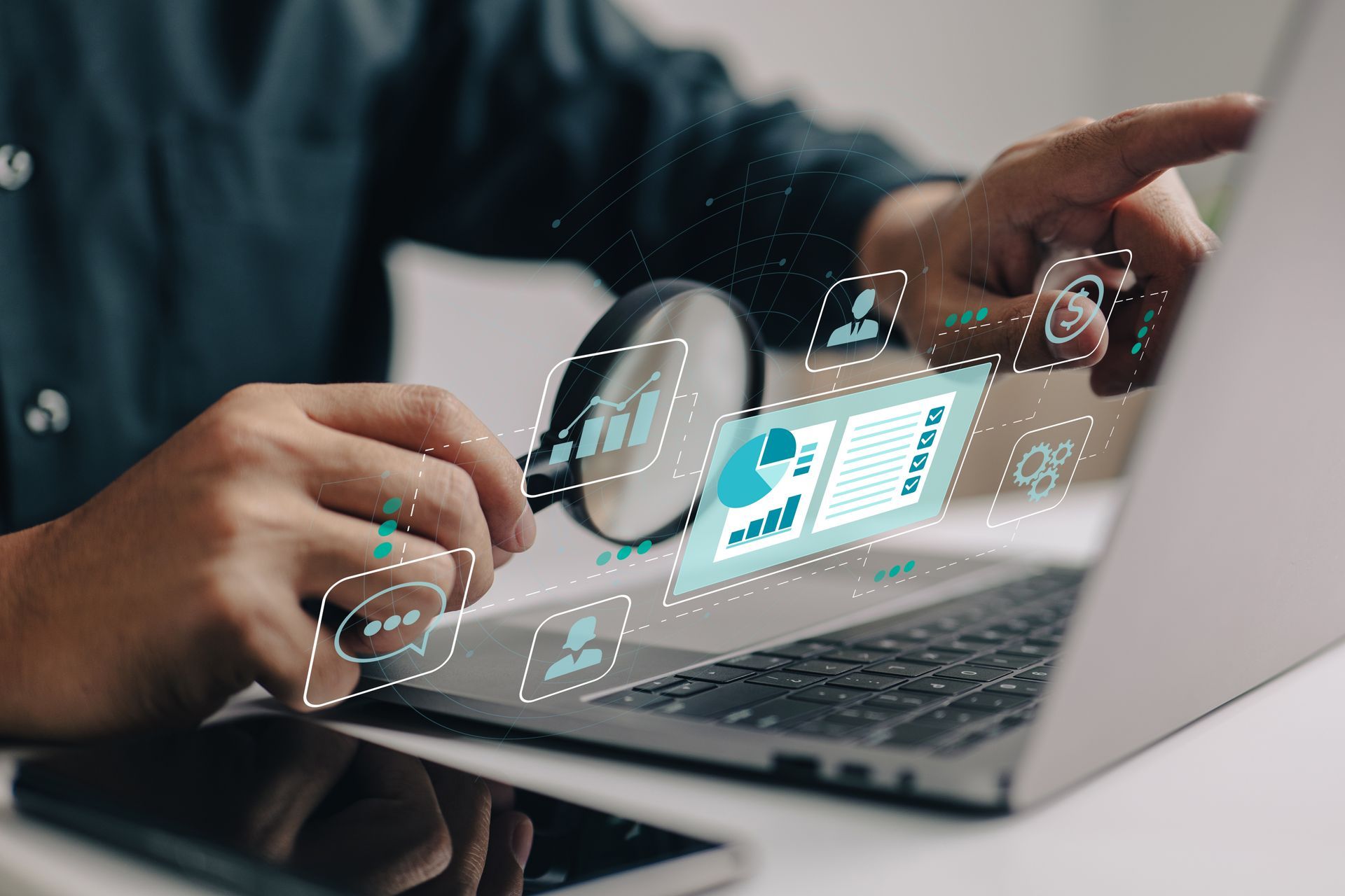 A person is looking at a laptop with a magnifying glass.