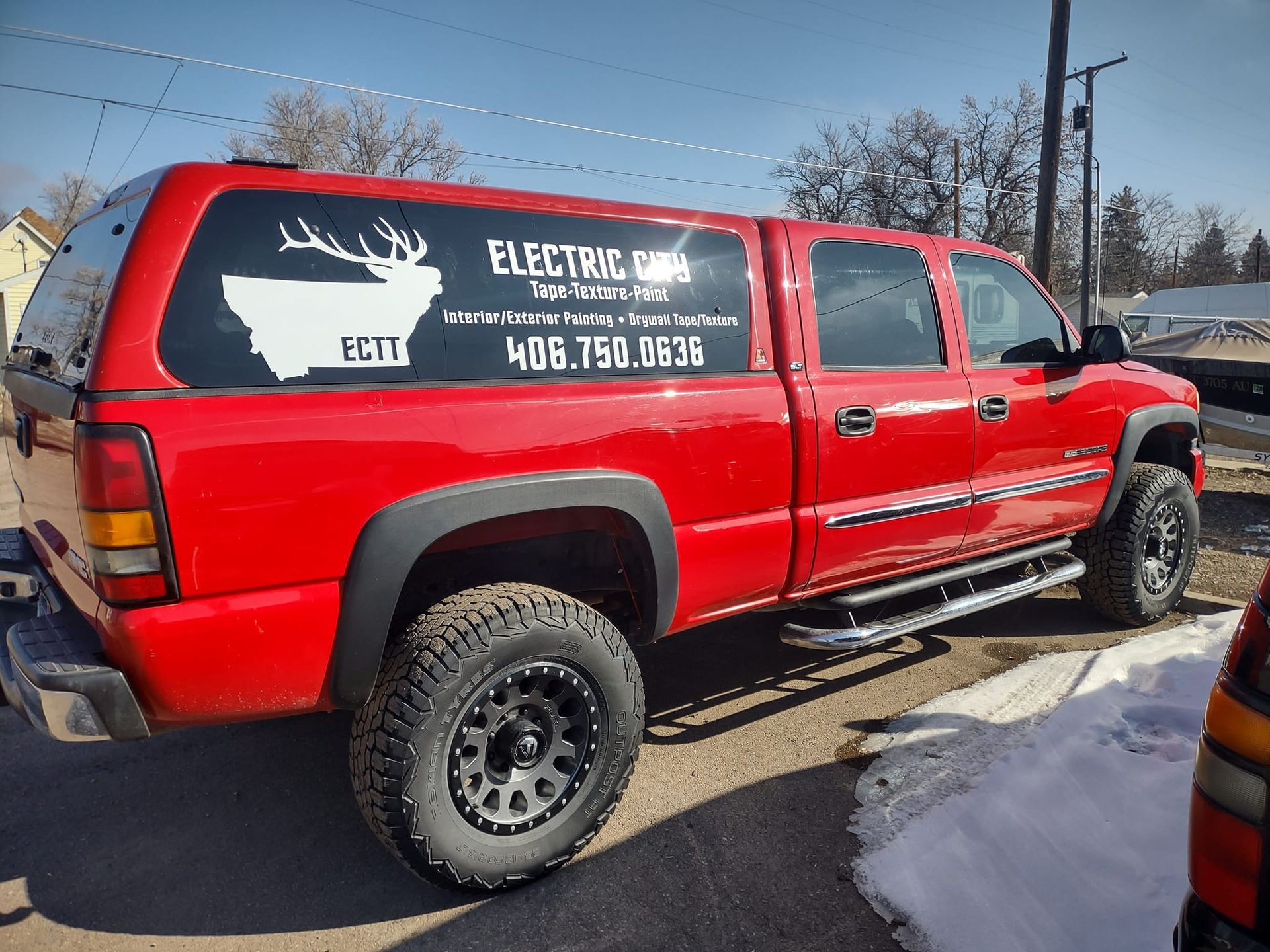Red pickup truck with a camper shell, featuring 