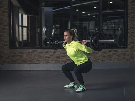 The lower legs of a man preparing to lift a barbell