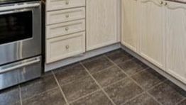 A kitchen with stainless steel appliances and tile floors.