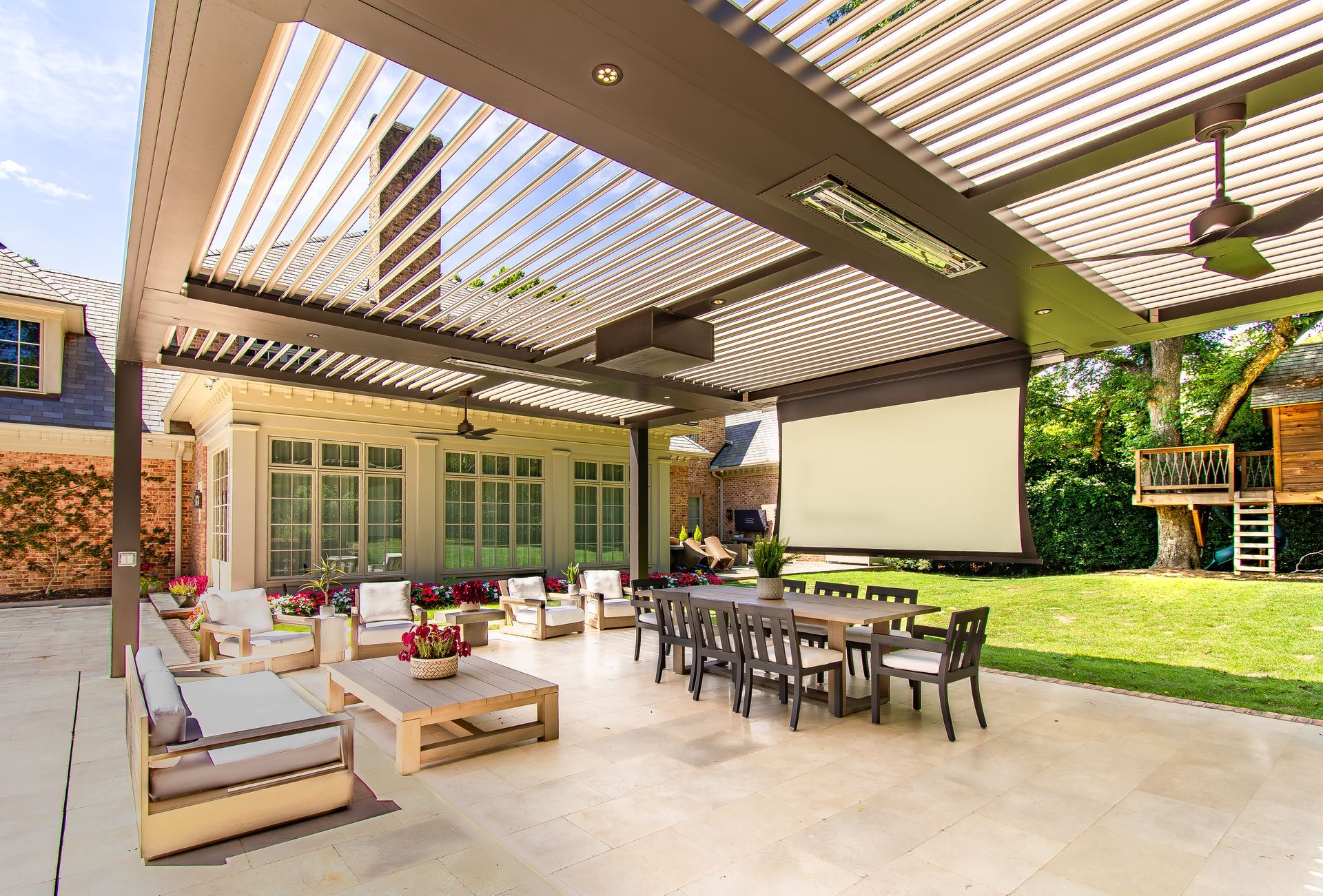 Patio with a retractable roof, seating area, dining table, and a playhouse in the backyard.