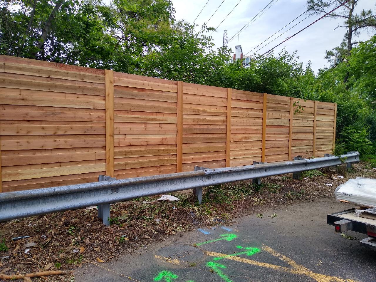 A wooden fence is sitting on the side of a road next to a highway. Clarksville, TN