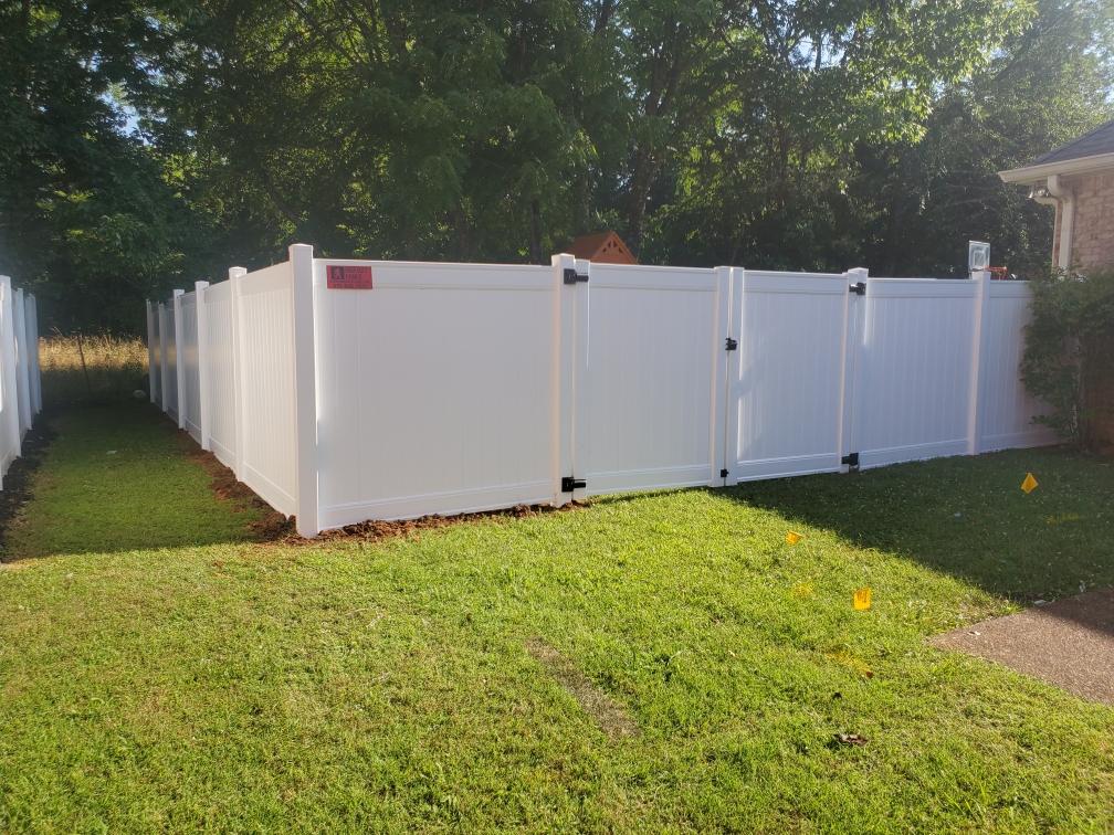 A white fence is sitting in the middle of a lush green yard. Clarksville, TN