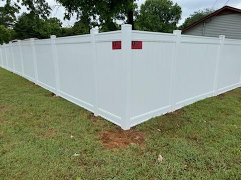 A white fence is sitting in the middle of a lush green field. Clarksville, TN