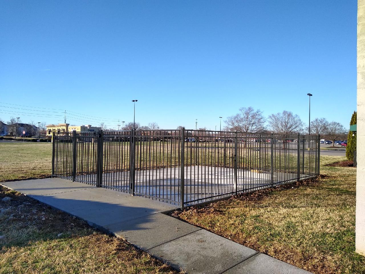 A fence surrounds a concrete walkway in a park. Clarksville, TN