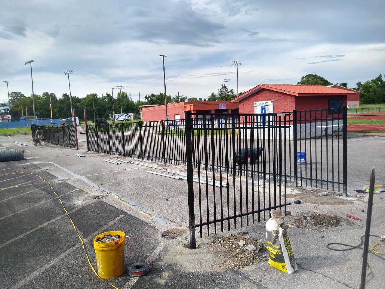 A yellow bucket is sitting on the sidewalk next to a metal fence. Clarksville, TN