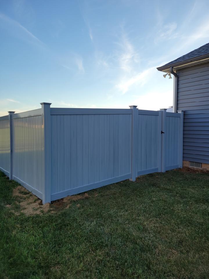 A white vinyl fence with a gate in the backyard of a house. Clarksville, TN