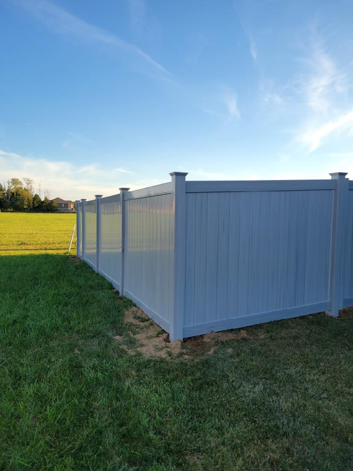 A white vinyl fence is sitting in the middle of a lush green field. Clarksville, TN
