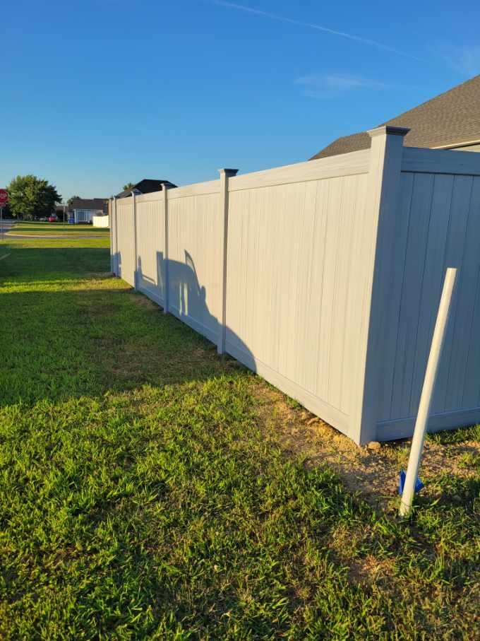 A white fence is sitting in the middle of a lush green field. Clarksville, TN