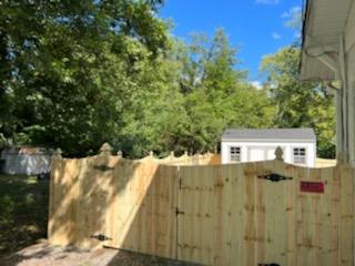 A wooden fence with a gate in front of a house. Clarksville, TN