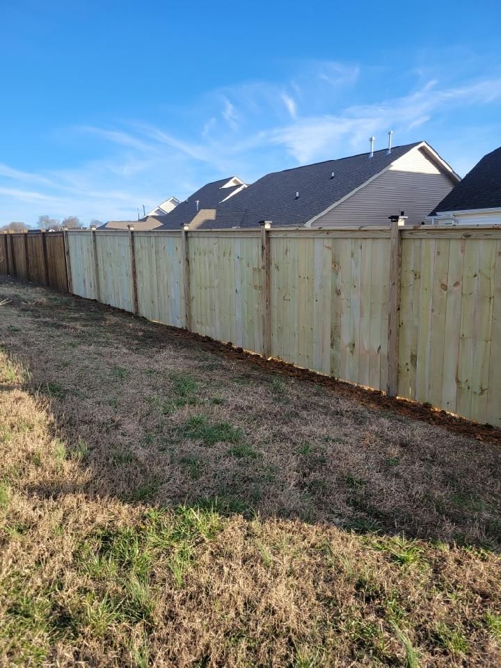 A wooden fence surrounds a grassy field in front of a house. Clarksville,TN