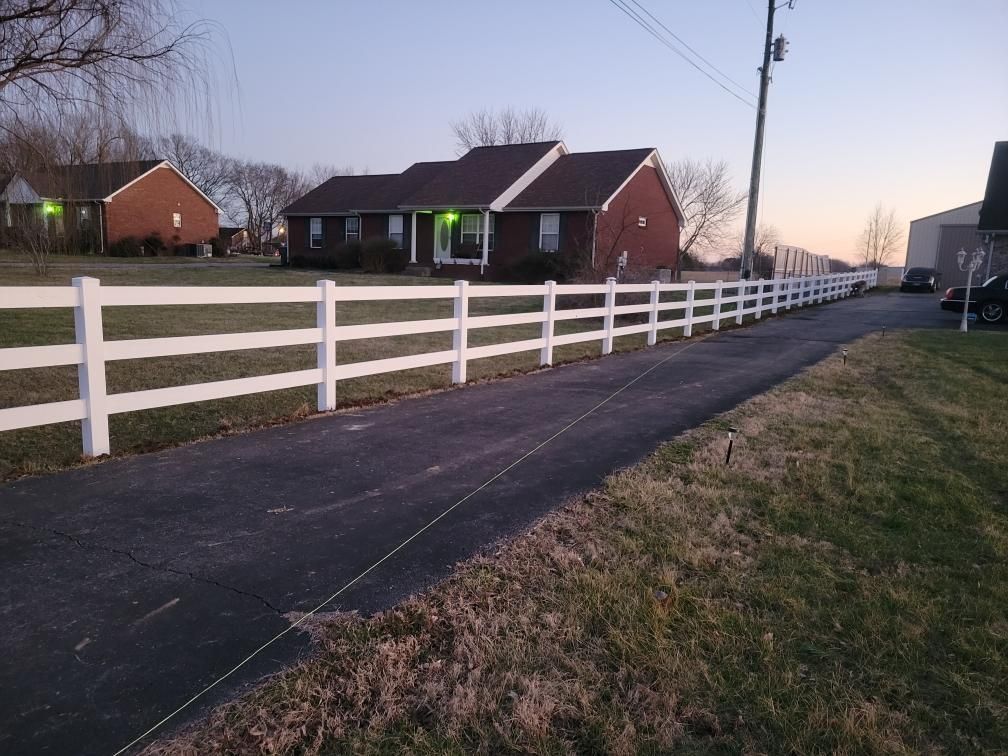 A white fence is along the side of a road in front of a house. Clarksville,TN