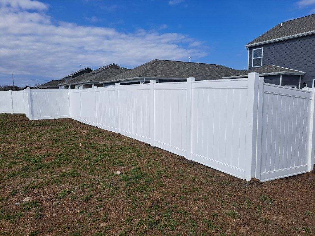 A white fence is in the backyard of a house. Middle, TN