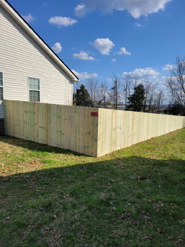 A wooden fence is in the backyard of a house. Middle, TN
