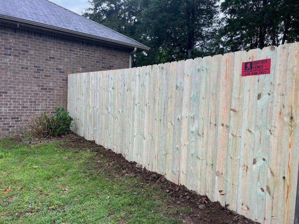 A wooden fence is sitting in front of a brick house. Clarksville,TN