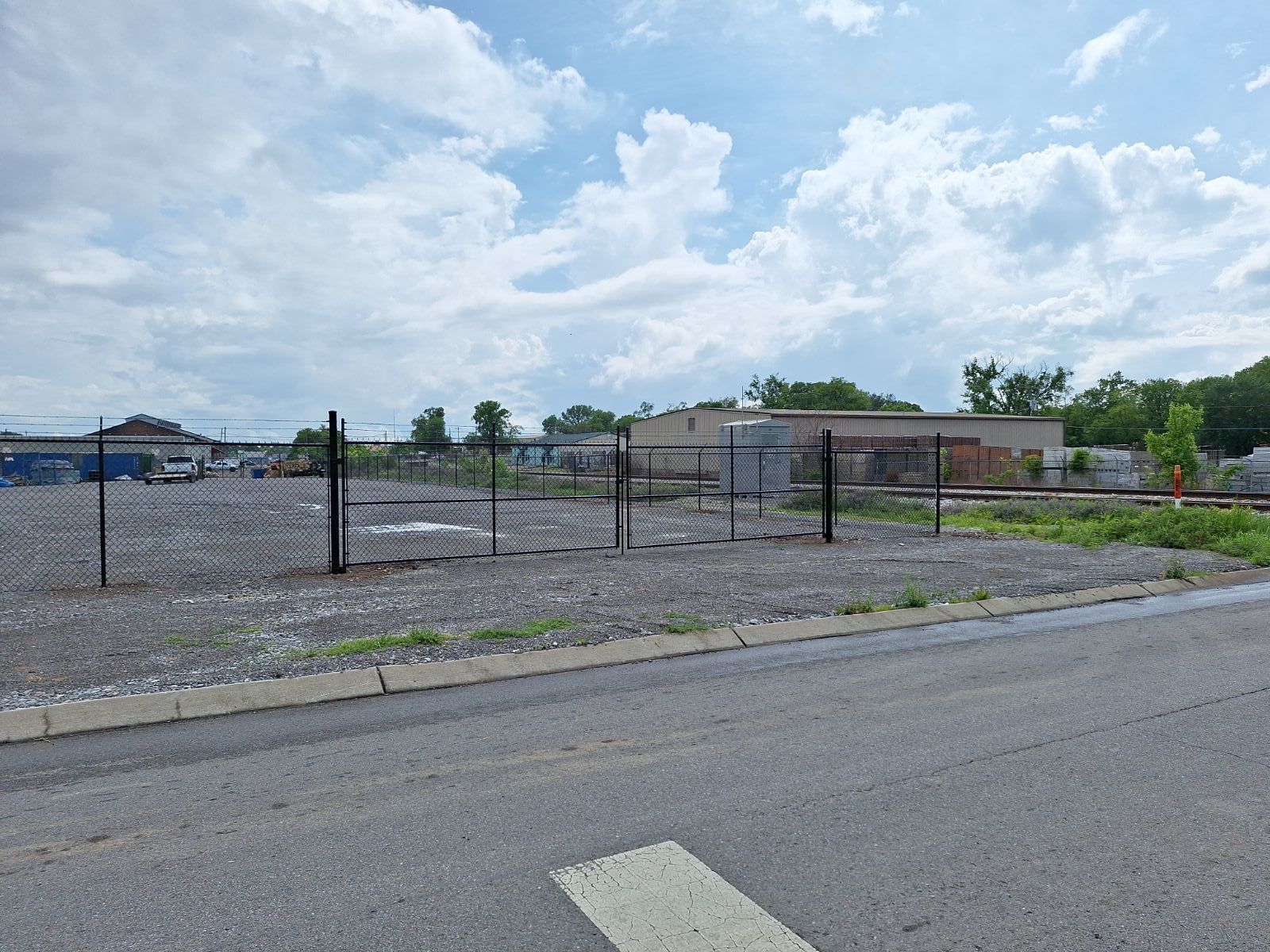 A fence surrounds a gravel lot next to a road. Clarksville, TN