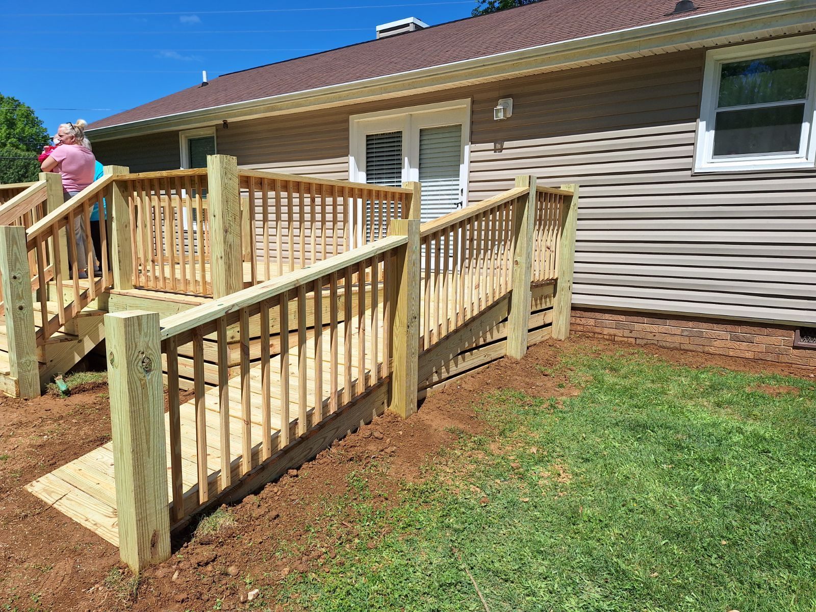 A woman is standing on a wooden deck next to a house. Middle, TN