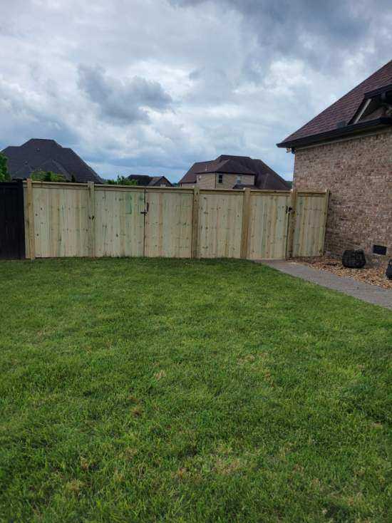 A wooden fence is in the backyard of a house. Middle, TN