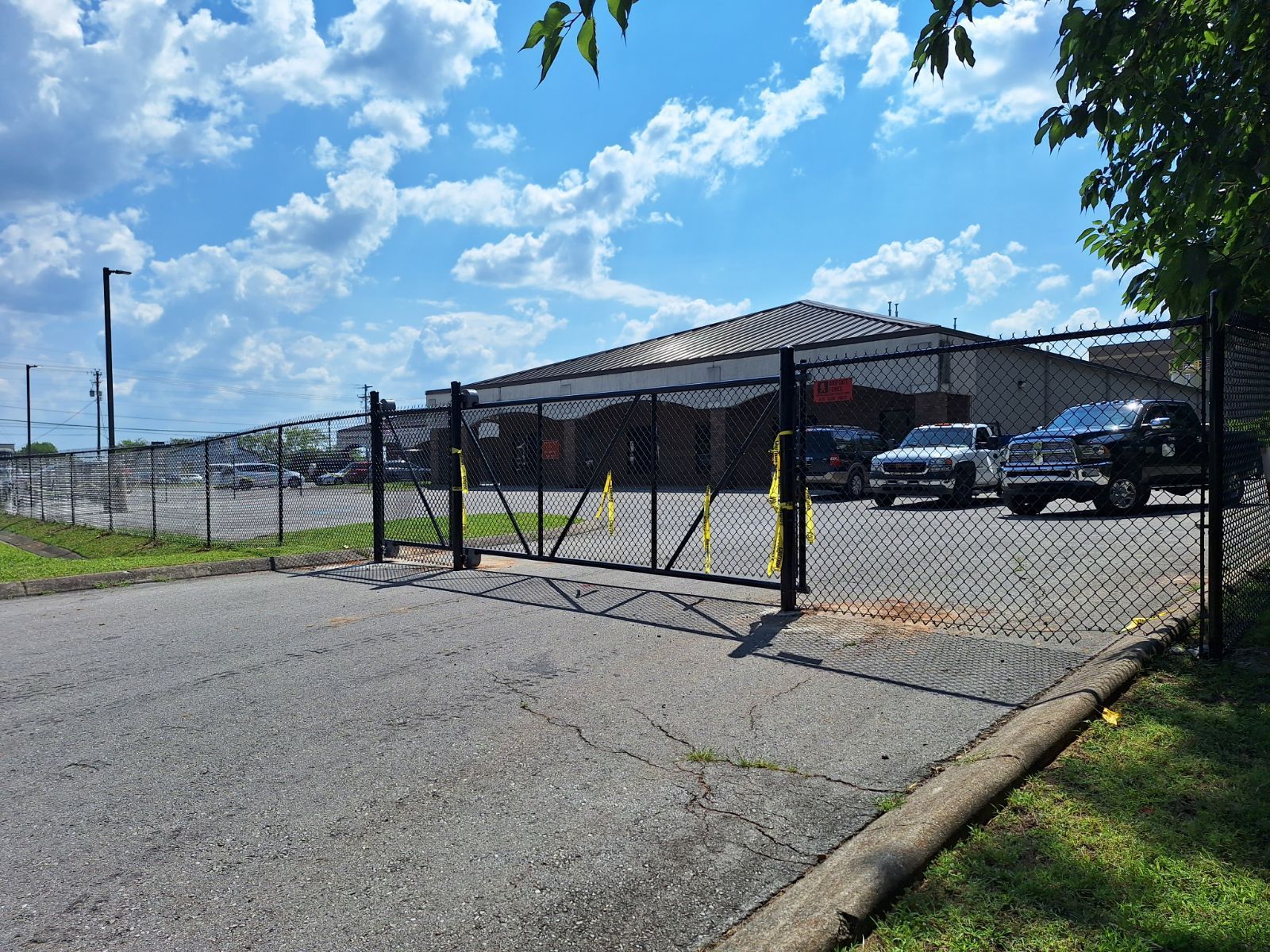A chain link fence surrounds a parking lot with cars parked in front of it. Clarksville, TN