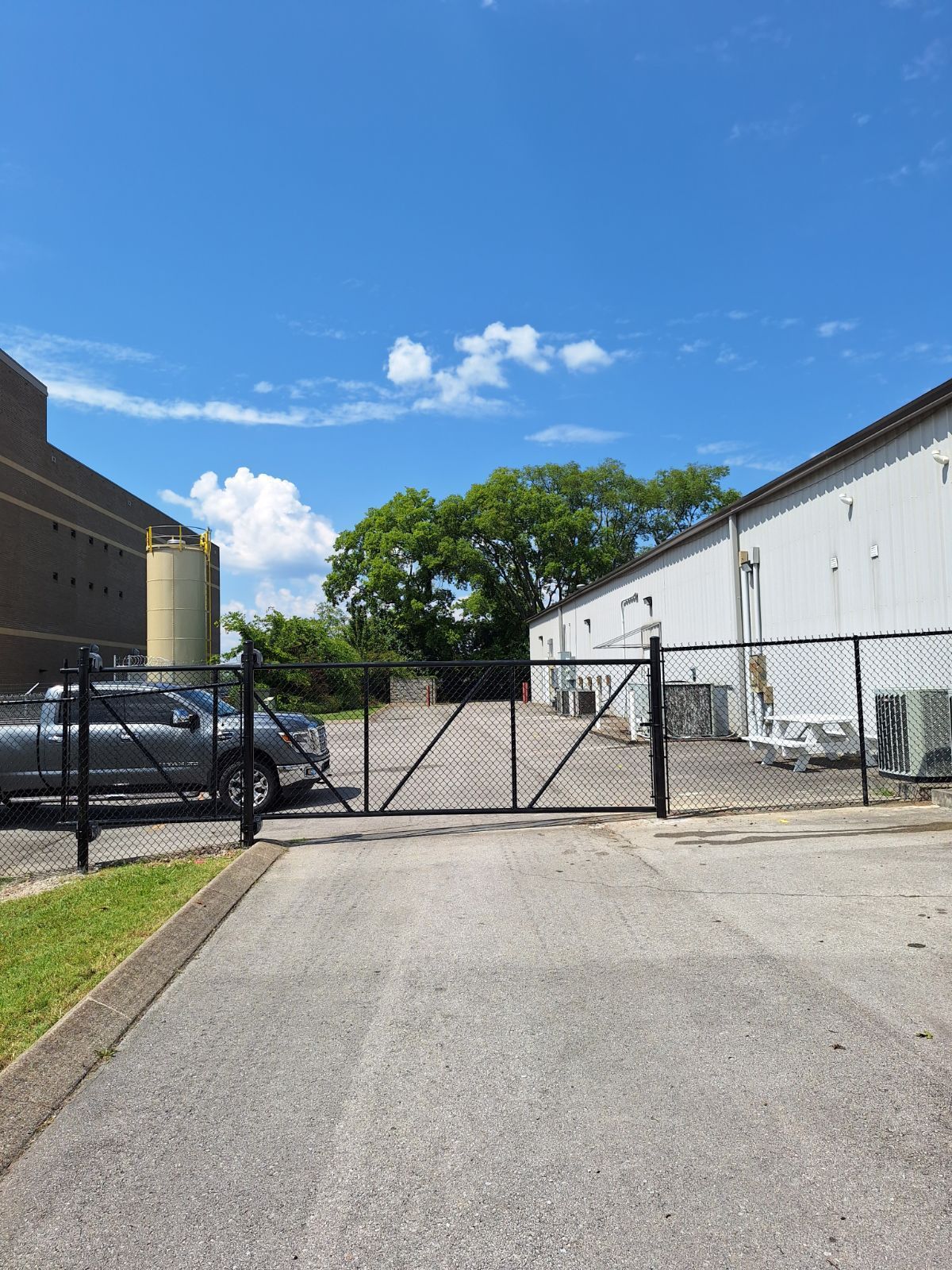 A fenced in parking lot with a truck parked in front of a building. Clarksville, TN