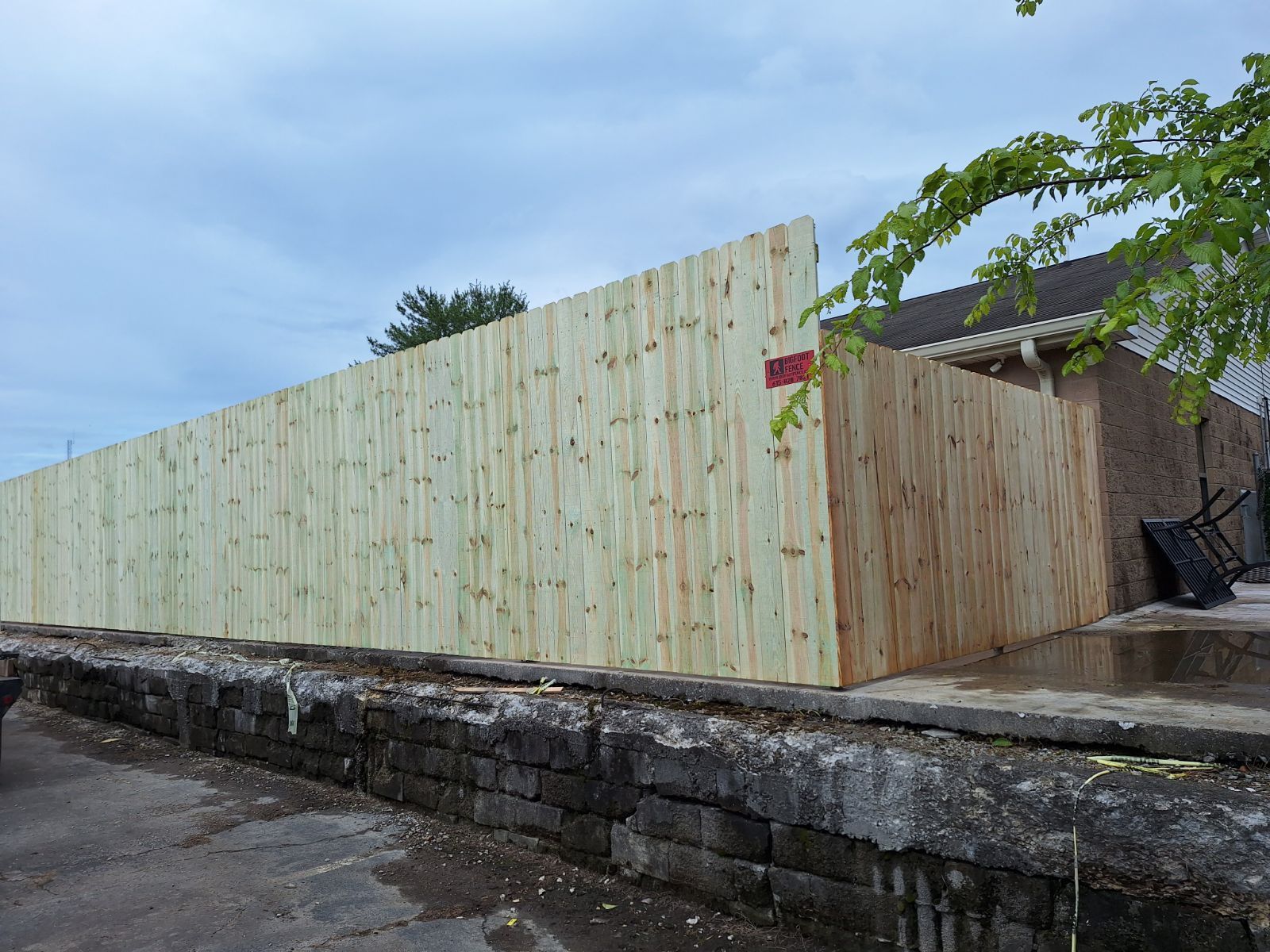 A large wooden fence is surrounding a stone wall. Clarksville, TN