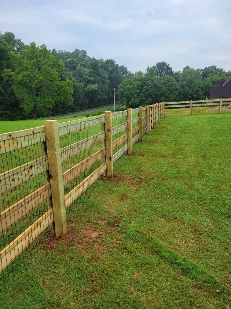 A wooden fence surrounds a lush green field. Middle, TN
