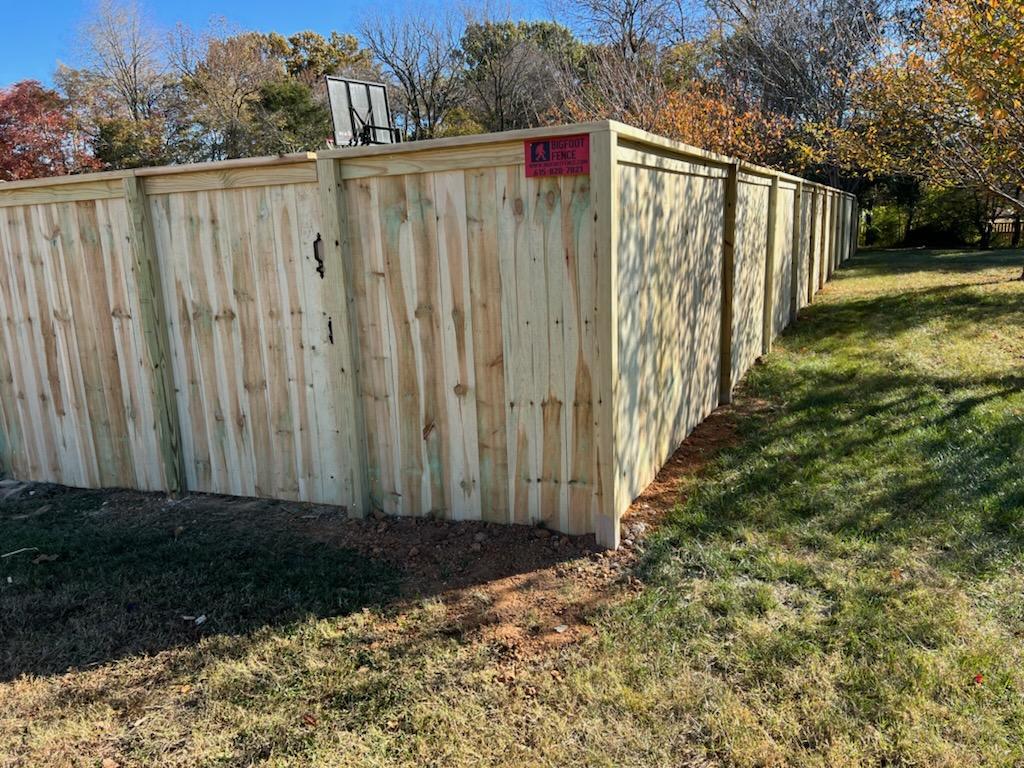 A wooden fence is sitting in the middle of a grassy field. Middle, TN