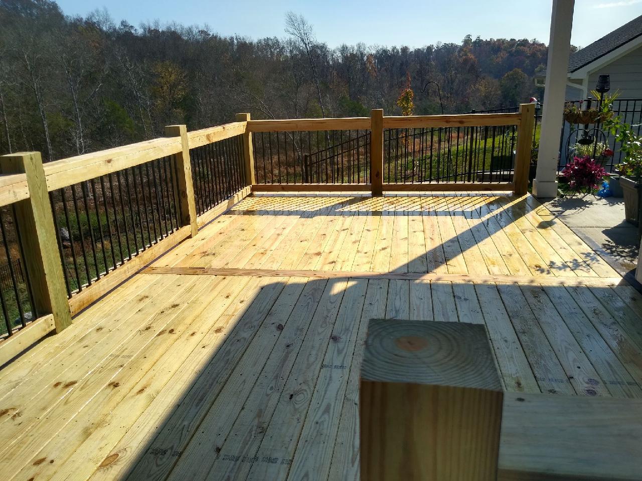 A wooden deck with a railing and a bench. Middle, TN