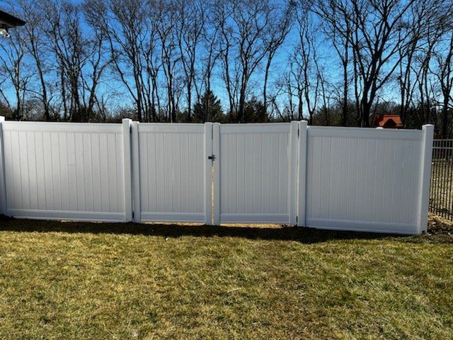 A white vinyl fence with a gate in the backyard. Clarksville, TN