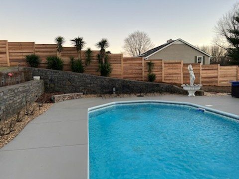 A large swimming pool surrounded by a wooden fence in a backyard. Clarksville, TN