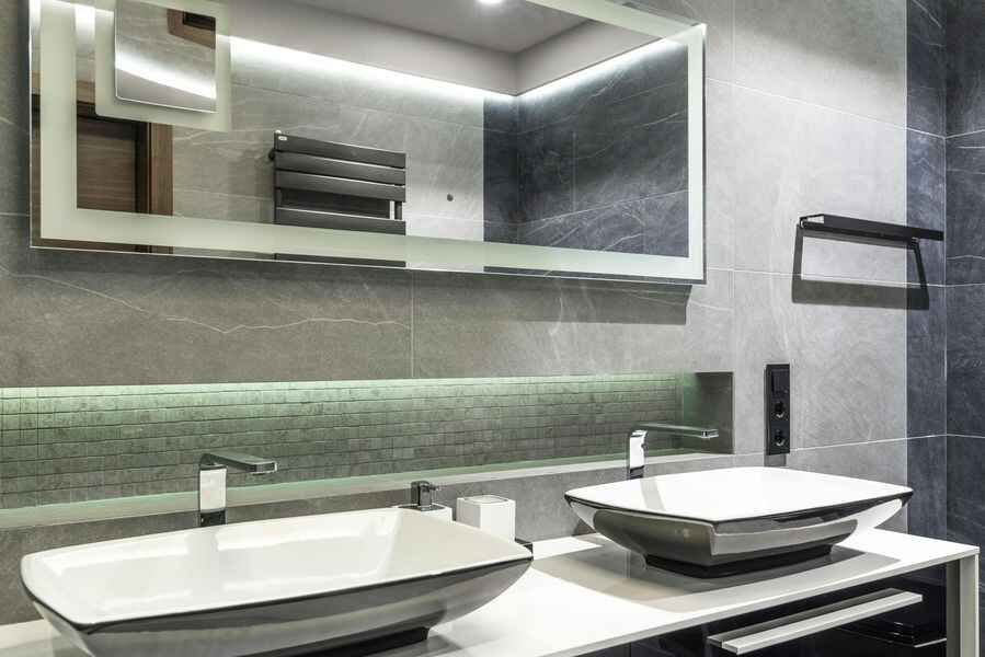 A bathroom with two sinks and a large mirror.