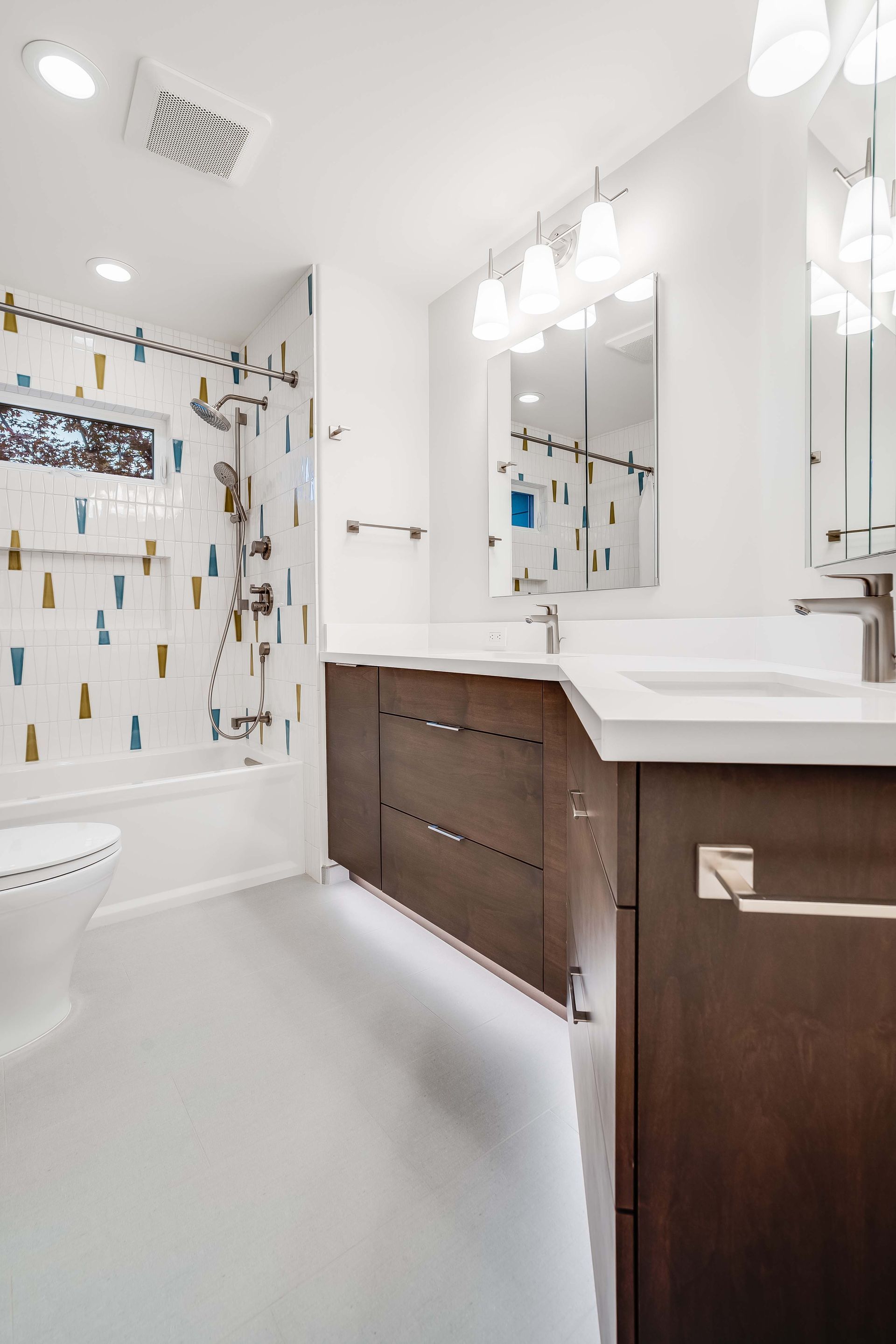 Modern bathroom with white walls, patterned shower, and dark wood vanity.