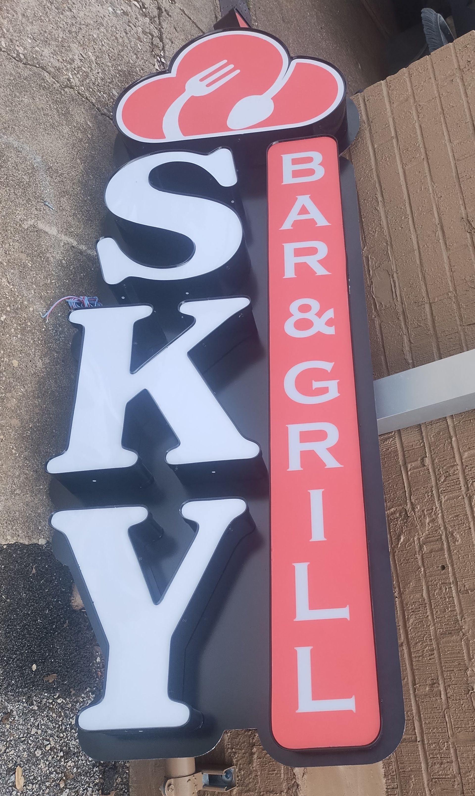 Sky Bar & Grill sign with white letters on black and red vertical panels