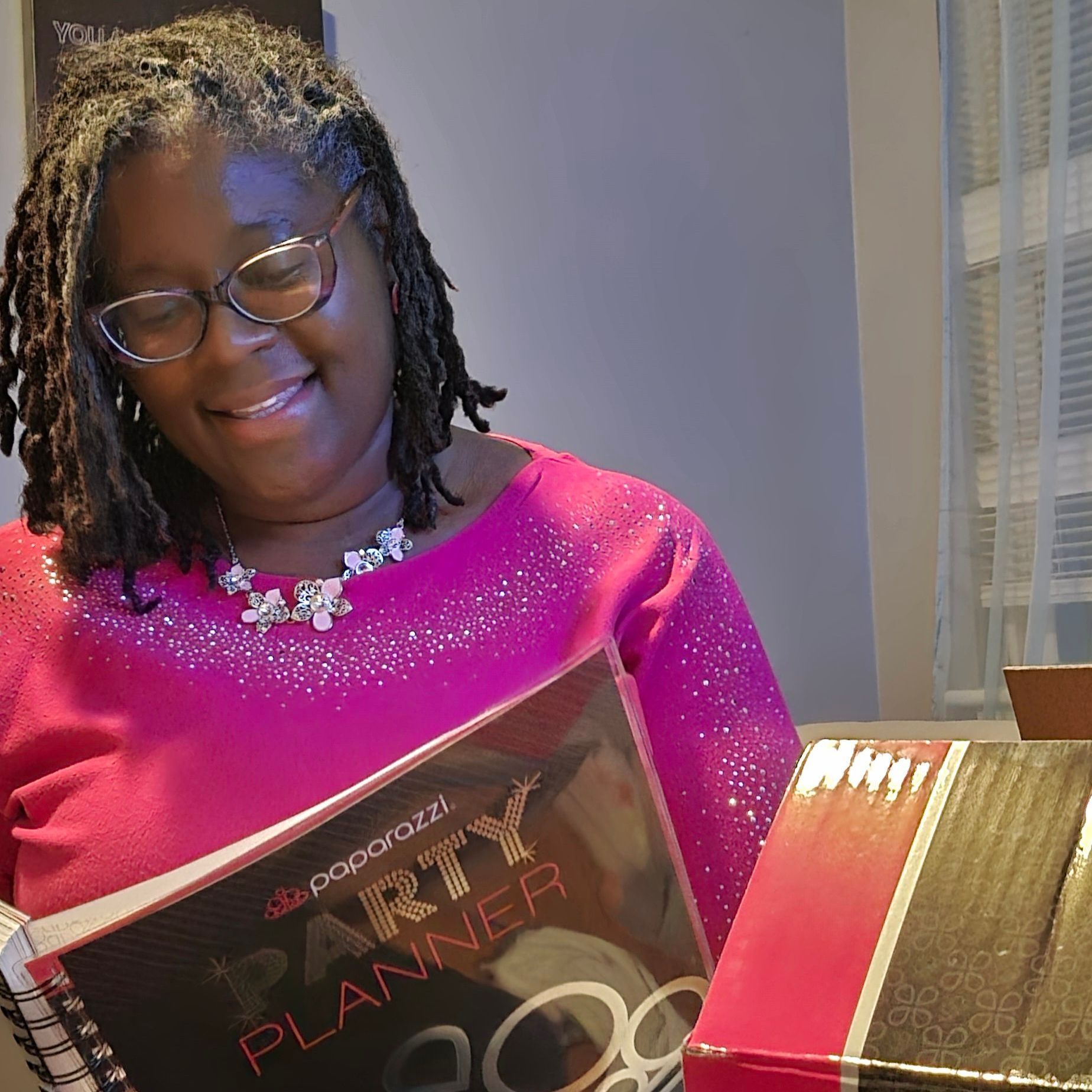 A woman in a pink shirt is holding a party planner