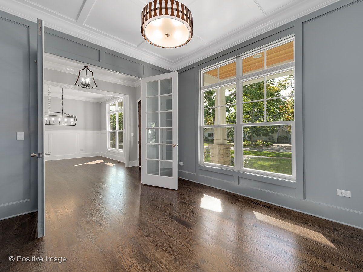 A large empty room with hardwood floors and lots of windows.