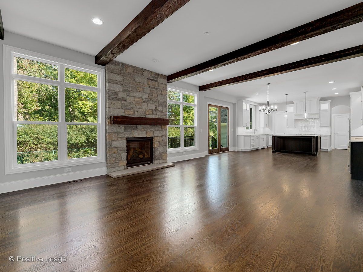 An empty living room with hardwood floors and a fireplace.