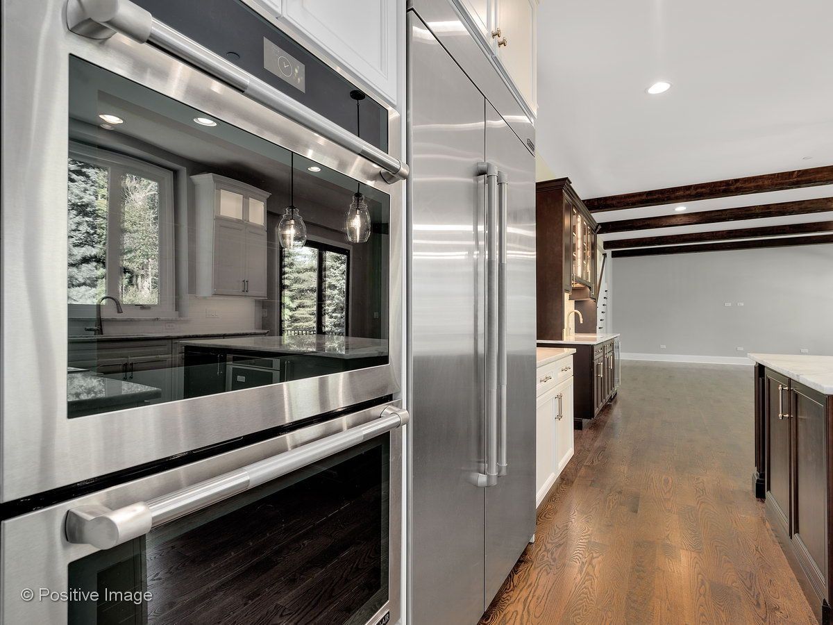 A kitchen with stainless steel appliances and wooden floors.
