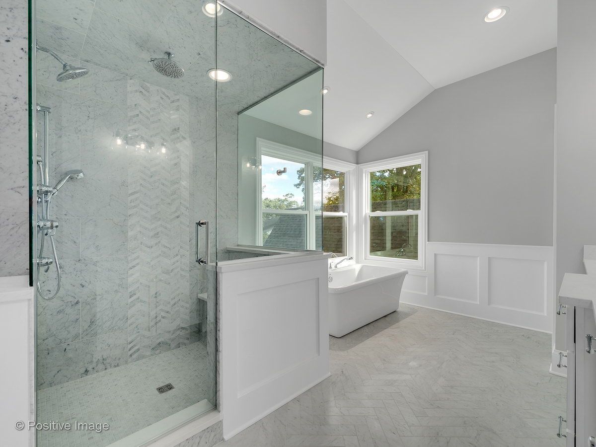 A bathroom with a walk in shower and a bathtub.