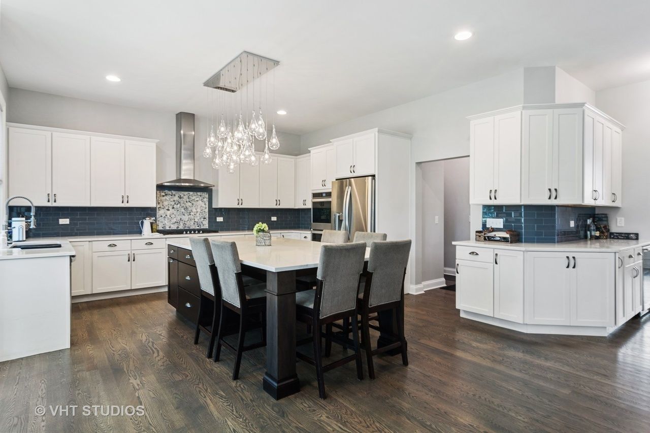 A large kitchen with white cabinets and a large island.