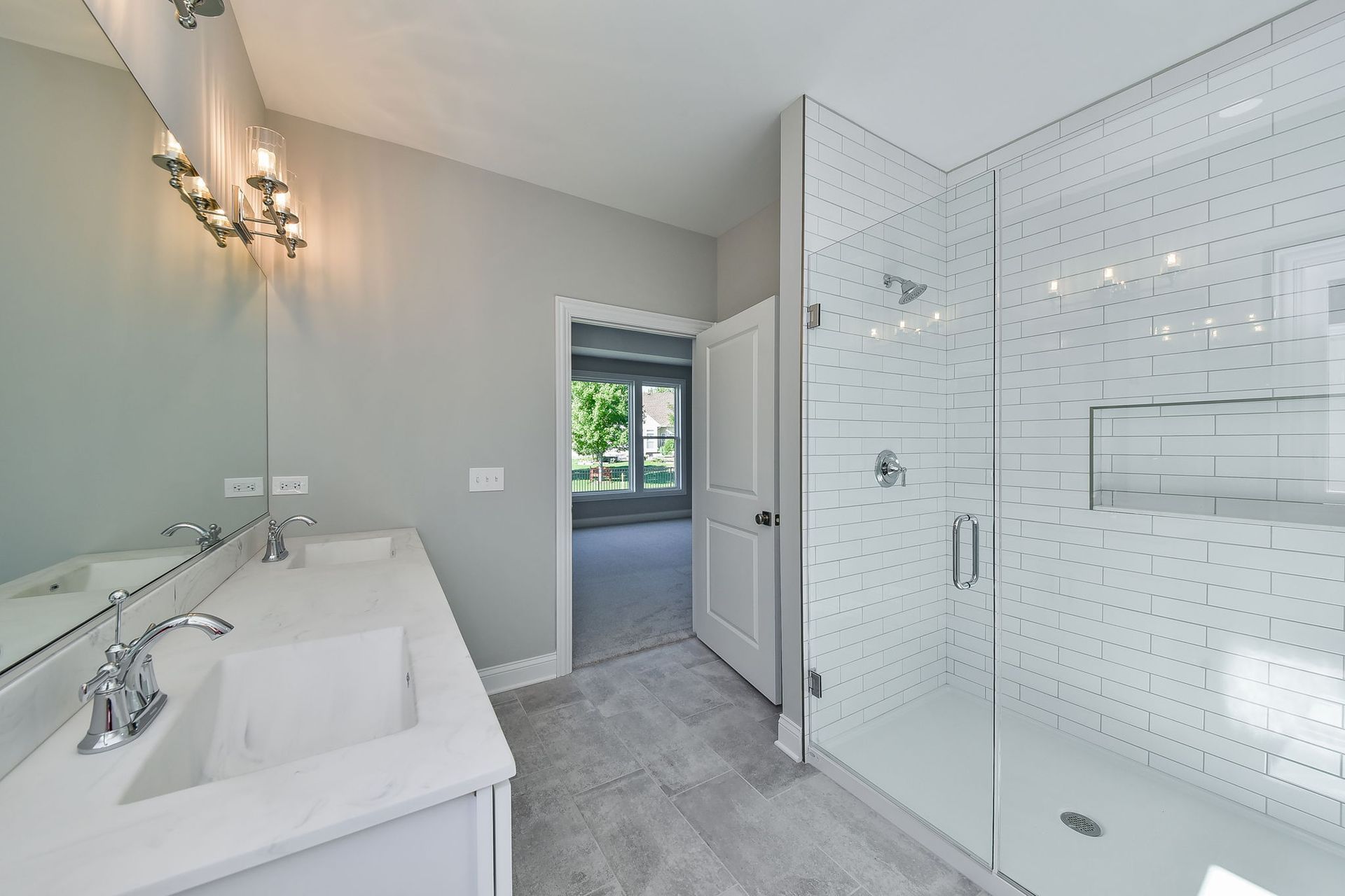 A bathroom with two sinks and a walk in shower.