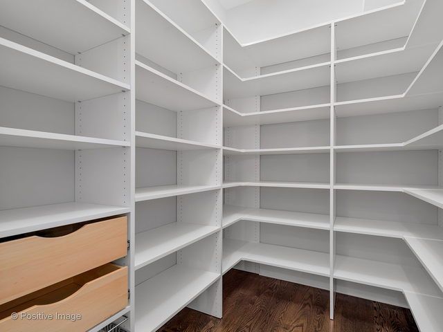 A walk in closet with lots of shelves and drawers.