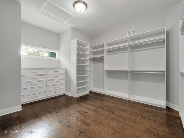 A walk in closet with lots of shelves and drawers.